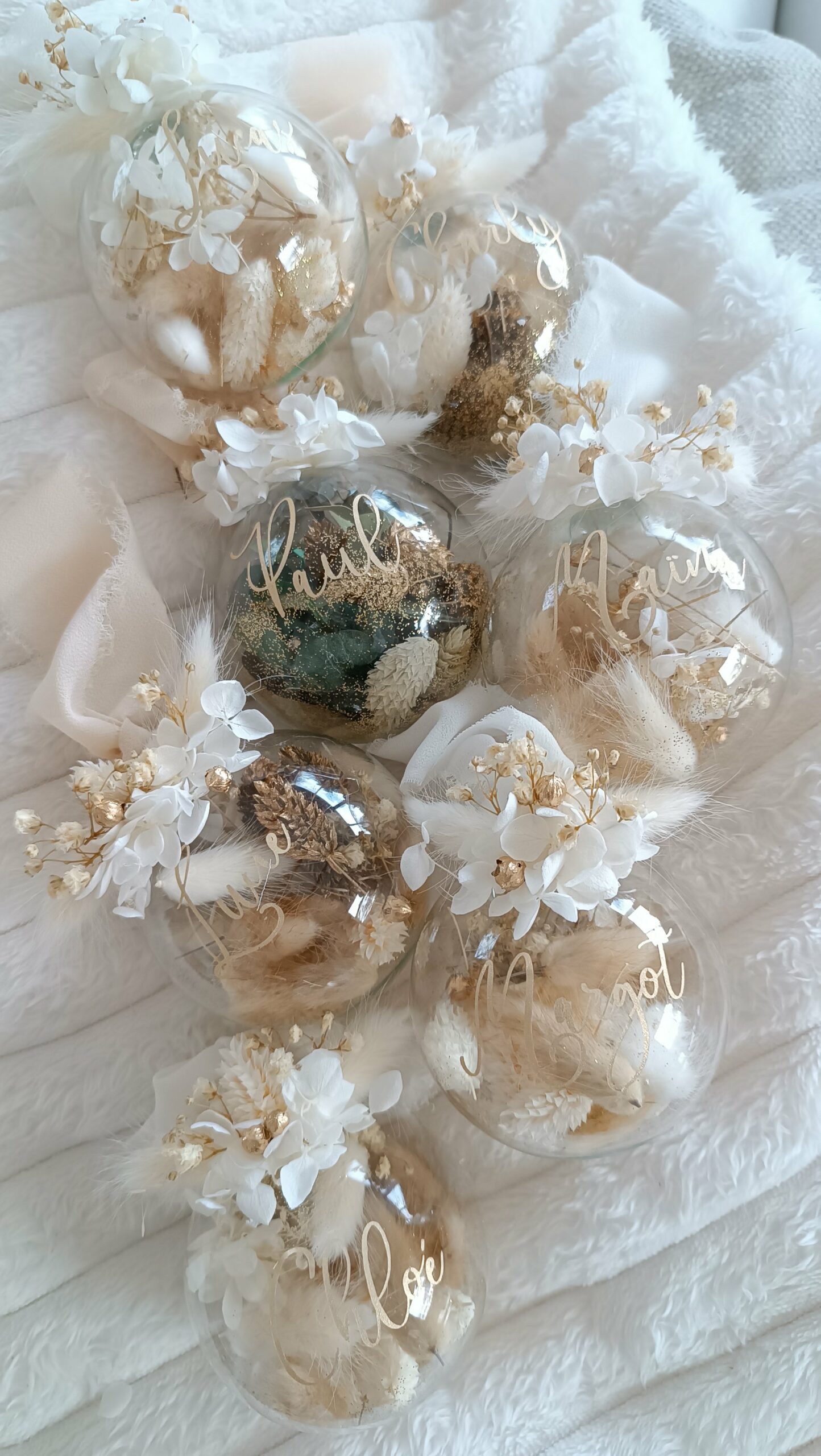 Boule de Noël en verre personnalisée avec prénom, remplie de fleurs séchées naturelles et décorée sur le dessus, idéale pour embellir le sapin et apporter une touche festive et élégante. Décoration de sapin de Noël originale, boule personnalisée en verre avec prénom gravé, contenant des fleurs séchées colorées, parfaite pour une ambiance chaleureuse et authentique. Boule de Noël artisanale en verre, personnalisable avec prénom, garnie de fleurs séchées à l’intérieur, un ornement raffiné pour sapin de Noël et décoration festive de fin d’année. Boue de noël pour mon 1er noël, joyeux noël , belles fêtes de fin d'année, cadeau à personnaliser, idée cadeau fait main à personnaliser avec prénom ou meesage. Ornement de Noël en verre transparent, boule personnalisée avec prénom et fleurs séchées, une décoration unique et naturelle pour sapin de Noël traditionnel ou moderne. Merry Christmas