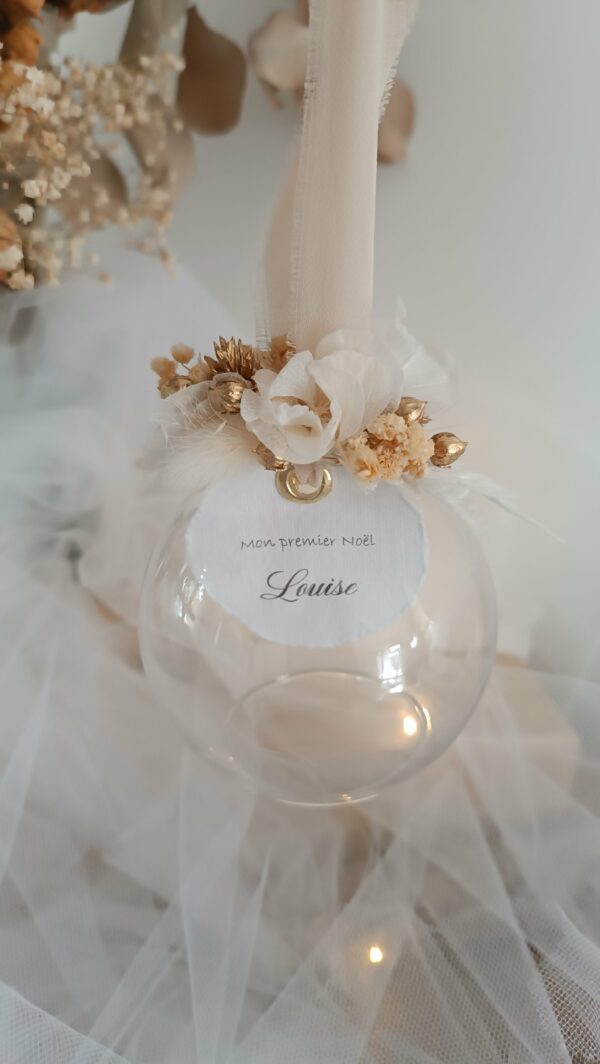 Boule de Noël en verre personnalisée avec prénom, remplie de fleurs séchées naturelles et décorée sur le dessus, idéale pour embellir le sapin et apporter une touche festive et élégante. Décoration de sapin de Noël originale, boule personnalisée en verre avec prénom gravé, contenant des fleurs séchées colorées, parfaite pour une ambiance chaleureuse et authentique. Boule de Noël artisanale en verre, personnalisable avec prénom, garnie de fleurs séchées à l’intérieur, un ornement raffiné pour sapin de Noël et décoration festive de fin d’année. Boue de noël pour mon 1er noël, joyeux noël , belles fêtes de fin d'année, cadeau à personnaliser, idée cadeau fait main à personnaliser avec prénom ou meesage. Ornement de Noël en verre transparent, boule personnalisée avec prénom et fleurs séchées, une décoration unique et naturelle pour sapin de Noël traditionnel ou moderne. Merry Christmas