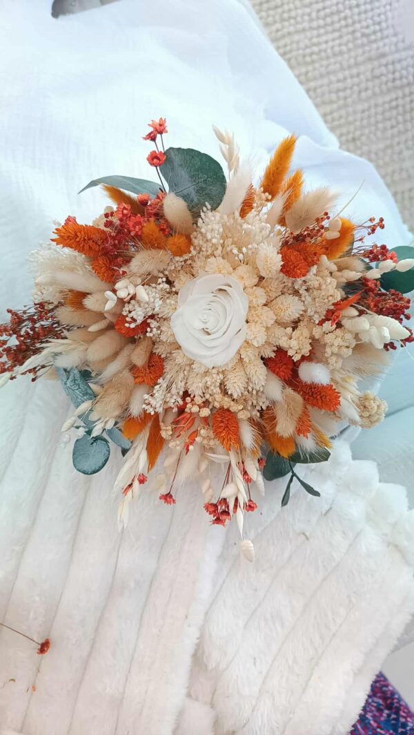 Bouquet de mariée en fleurs séchées aux teintes douces et romantiques, composé de roses stabilisées, d’eucalyptus et de fleurs champêtres, parfait pour un mariage bohème ou élégant.