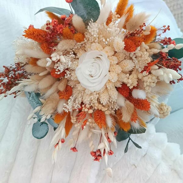Bouquet de mariée en fleurs séchées aux teintes douces et romantiques, composé de roses stabilisées, d’eucalyptus et de fleurs champêtres, parfait pour un mariage bohème ou élégant.