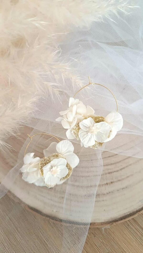 Boucles d’oreilles créoles dorées en acier inoxydable ornées de fleurs séchées blanches et dorées, création artisanale faite main. Boucles d’oreilles créoles dorées en acier inoxydable décorées de fleurs séchées blanches et dorées, bijou fait main au style naturel et élégant. bijoux femme en fleur séchées, cadeau noël femme, idée cadeau bijoux femme bohême et poétique, créoles blanches et doré en fleurs séchées. Boucle d'oreilles à offrir. Boucles d'oreilles créoles pour mariage ou èvenement. Cadeau fête des mamans, idée cadeau fait main fête des grands mères - Boucles d’oreilles créoles dorées en fleurs séchées blanches, création artisanale. Bijoux à offrir naturelle et poétique, création artisanale