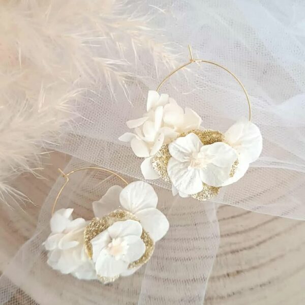 Boucles d’oreilles créoles dorées en acier inoxydable ornées de fleurs séchées blanches et dorées, création artisanale faite main. Boucles d’oreilles créoles dorées en acier inoxydable décorées de fleurs séchées blanches et dorées, bijou fait main au style naturel et élégant. bijoux femme en fleur séchées, cadeau noël femme, idée cadeau bijoux femme bohême et poétique, créoles blanches et doré en fleurs séchées. Boucle d'oreilles à offrir. Boucles d'oreilles créoles pour mariage ou èvenement. Cadeau fête des mamans, idée cadeau fait main fête des grands mères - Boucles d’oreilles créoles dorées en fleurs séchées blanches, création artisanale. Bijoux à offrir naturelle et poétique, création artisanale