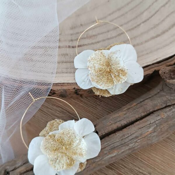 Boucles d’oreilles créoles dorées en acier inoxydable ornées de fleurs séchées blanches et dorées, création artisanale faite main. Boucles d’oreilles créoles dorées en acier inoxydable décorées de fleurs séchées blanches et dorées, bijou fait main au style naturel et élégant. bijoux femme en fleur séchées, cadeau noël femme, idée cadeau bijoux femme bohême et poétique, créoles blanches et doré en fleurs séchées. Boucle d'oreilles à offrir. Boucles d'oreilles créoles pour mariage ou èvenement. Cadeau fête des mamans, idée cadeau fait main fête des grands mères - Boucles d’oreilles créoles dorées en fleurs séchées blanches, création artisanale. Bijoux à offrir naturelle et poétique, création artisanale