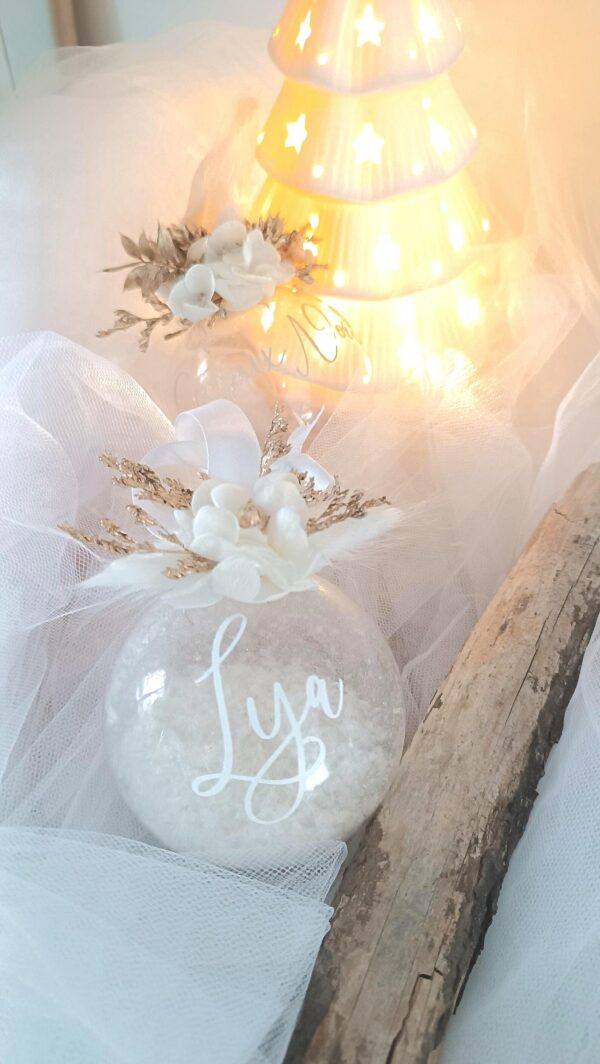 Boule de Noël en verre personnalisée avec prénom, remplie de fleurs séchées naturelles et décorée sur le dessus, idéale pour embellir le sapin et apporter une touche festive et élégante. Décoration de sapin de Noël originale, boule personnalisée en verre avec prénom gravé, contenant des fleurs séchées colorées, parfaite pour une ambiance chaleureuse et authentique. Boule de Noël artisanale en verre, personnalisable avec prénom, garnie de fleurs séchées à l’intérieur, un ornement raffiné pour sapin de Noël et décoration festive de fin d’année. Boue de noël pour mon 1er noël, joyeux noël , belles fêtes de fin d'année, cadeau à personnaliser, idée cadeau fait main à personnaliser avec prénom ou meesage. Ornement de Noël en verre transparent, boule personnalisée avec prénom et fleurs séchées, une décoration unique et naturelle pour sapin de Noël traditionnel ou moderne. Merry Christmas