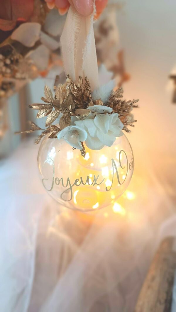Boule de Noël en verre personnalisée avec prénom, remplie de fleurs séchées naturelles et décorée sur le dessus, idéale pour embellir le sapin et apporter une touche festive et élégante. Décoration de sapin de Noël originale, boule personnalisée en verre avec prénom gravé, contenant des fleurs séchées colorées, parfaite pour une ambiance chaleureuse et authentique. Boule de Noël artisanale en verre, personnalisable avec prénom, garnie de fleurs séchées à l’intérieur, un ornement raffiné pour sapin de Noël et décoration festive de fin d’année. Boue de noël pour mon 1er noël, joyeux noël , belles fêtes de fin d'année, cadeau à personnaliser, idée cadeau fait main à personnaliser avec prénom ou meesage. Ornement de Noël en verre transparent, boule personnalisée avec prénom et fleurs séchées, une décoration unique et naturelle pour sapin de Noël traditionnel ou moderne. Merry Christmas