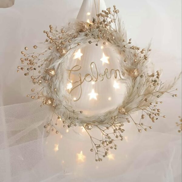 Suspension de Noël artisanale personnalisée en forme de mini couronne, décorée de fleurs séchées de pampas et de boom dorées, avec un prénom en fil doré, faite main, idéale pour décorer le sapin de Noël ou une porte dans un style naturel et poétique. Suspension de noël avec pampa - Ornement sapin de noël chic et bohème à personnaliser - Décoration sapin de noël avec prénom ou mot doux - Idée cadeau à offrir pour noël avec fleurs séchées